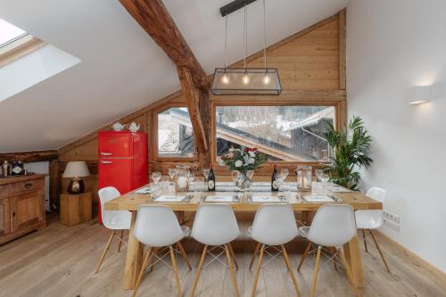 a dining room with a long table and white chairs at Chalet Vogue in Morzine