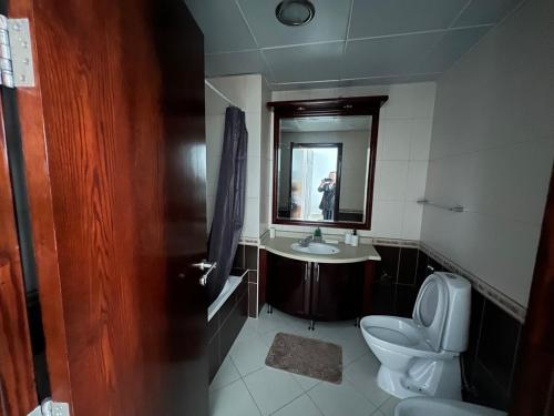 een badkamer met een toilet, een wastafel en een spiegel bij Opal Tower in Dubai