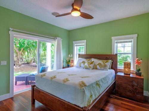 a bedroom with a bed with green walls and a fan at Hale Aulani in Princeville