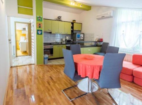 a living room with a red table and blue chairs at Apartments Galić in Ploče