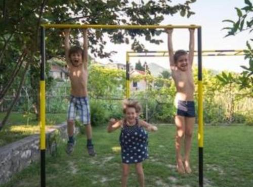 two boys and a girl playing on a swing at Apartments Galić in Ploče