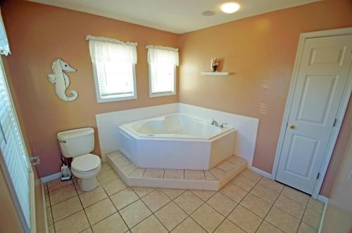 a bathroom with a white tub and a toilet at KH4508- Surf Par-Tee in Kitty Hawk