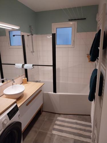 une salle de bain avec un lavabo, une baignoire et des toilettes dans l'établissement T2 moderne à deux pas de la gare - avec parking, à Nantes