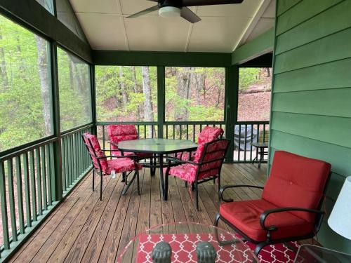 a screened in porch with a table and chairs at Chestnut Ridge in Connestee in Rosman