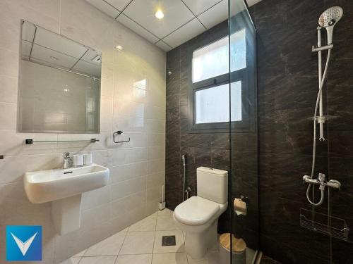 a bathroom with a toilet and a sink and a shower at 3BR Modern Seashore Private Villa with swimming Pool in Fujairah