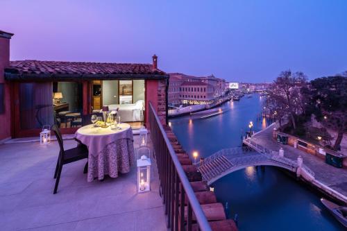 a balcony with a table and a view of a river at Hotel Santa Chiara in Venice