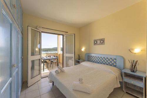 ein Schlafzimmer mit Bett und Meerblick in der Unterkunft Golfo Aranci Apartments With Ac in Marinella