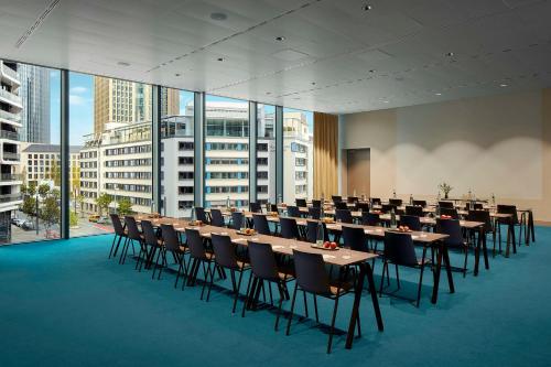 a conference room with tables and chairs and windows at NH Collection Frankfurt Spin Tower in Frankfurt/Main