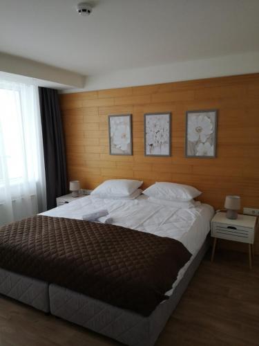 a bedroom with a large bed with a wooden wall at Forest Chamkoria Apartment in Borovets