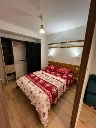 - une chambre avec un lit doté d'un couvre-lit rouge dans l'établissement Charmant appartement, à Saint-Claude