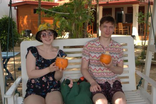 a man and a woman sitting on a white bench at Tomorrowland Beach Villas in Tangalle