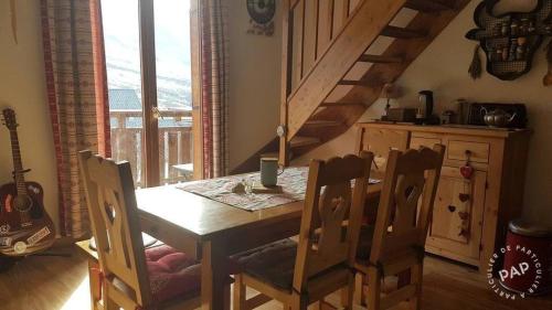 une salle à manger avec une table et des chaises et un escalier dans l'établissement Appartement Nez-à-nez à Albiez, à Albiez-Montrond