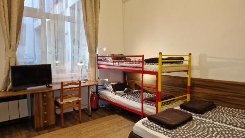 a room with two bunk beds and a desk at Dombóvári way apartment in Budapest