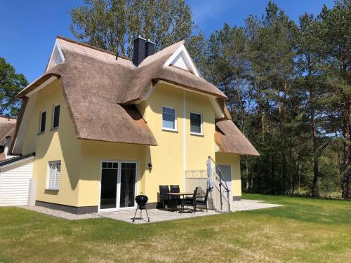 a large yellow house with a thatched roof at Ankerplatz in Zirchow