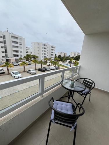 a table and chairs on a balcony with a view of a city at Acogedor departamento cerca de avenida del Mar in La Serena