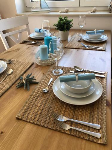 a table set with plates and silverware on a wooden table at Ankerplatz in Zirchow