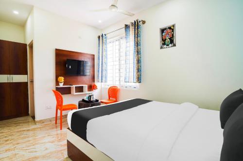 a bedroom with a bed and a table and chairs at Hotel O SK Comforts in Bengaluru