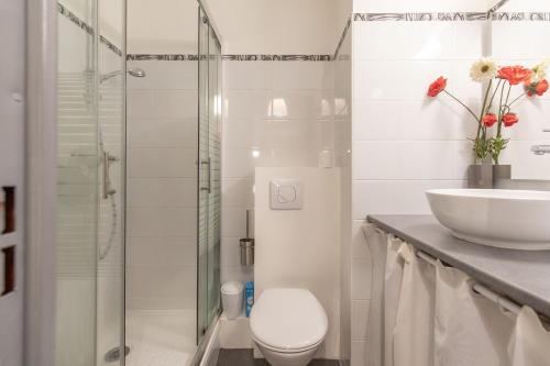 une salle de bain blanche avec des toilettes et un lavabo dans l'établissement Cosy Marmottes - Au cœur du Parc National, à Barèges