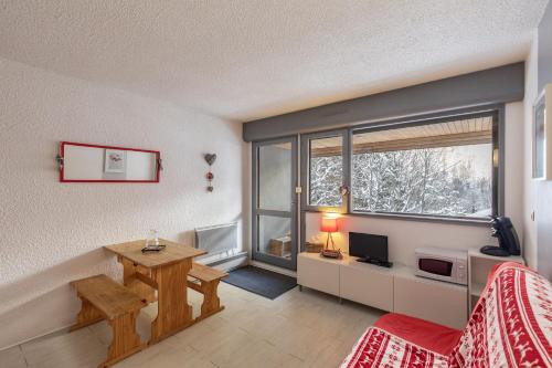 - un salon avec un bureau et une fenêtre dans l'établissement Cosy Marmottes - Au cœur du Parc National, à Barèges