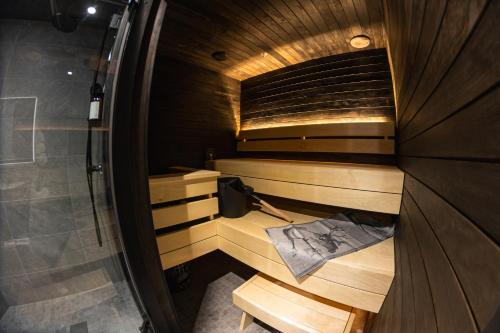 a wooden sauna with a bench in a room at Hotel Ylläsrinne Deluxe in Ylläsjärvi