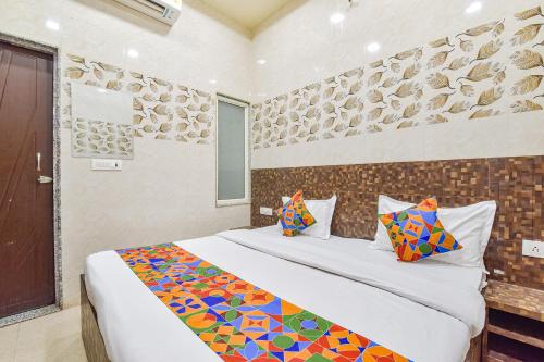 a bedroom with a large bed with colorful pillows at FabHotel Maa Gayatri Sadan - Nr Pram Mandir Shree Banke Bihari Temple in Vrindāvan