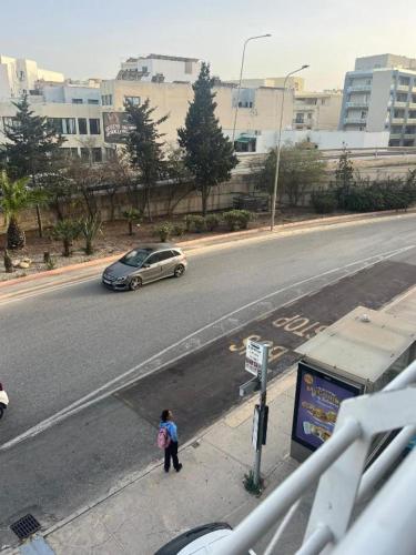 a person standing on a street with a car on the road at Giotto - Room 1 in Msida