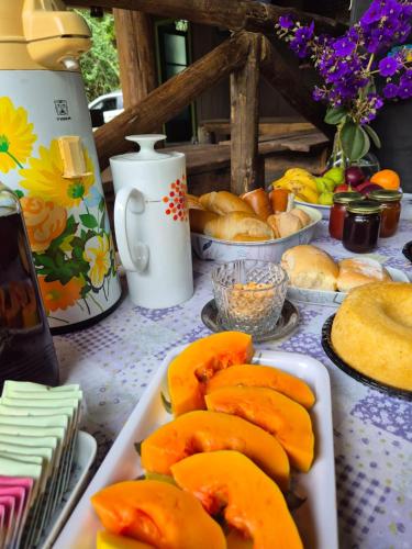 a table topped with plates of peaches and other foods at Glamping Meraki Brasil in Antonina