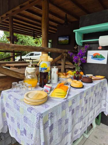 a table with plates of food on it at Glamping Meraki Brasil in Antonina