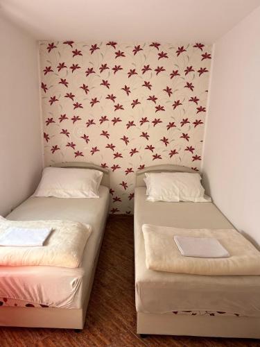 two beds in a room with a wallpaper with bats at Apartments Dijana in Kotor