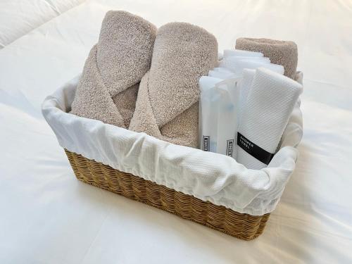 a basket with towels and detergents on a bed at Busan Vacance Stay, cozy house in Busan