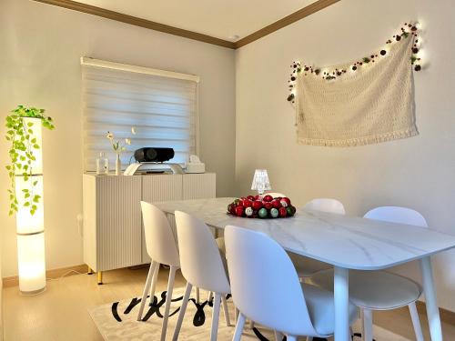 a dining room with a blue table and white chairs at Busan Vacance Stay, cozy house in Busan