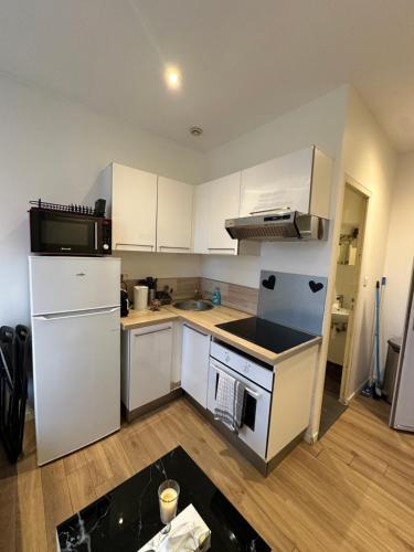 une cuisine avec des armoires blanches et un four à plaques de cuisson dans l'établissement # Le 8 # Joli petit F2 tout équipé, Mulhouse centre, à Mulhouse
