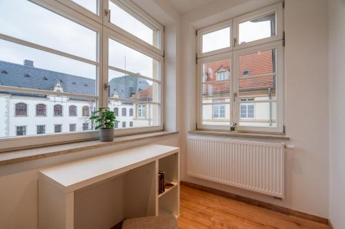 a white room with two windows and a table at In 2 Minuten am Bahnhof - traumhaftes Apartment mitten in Halle No3 in Halle an der Saale