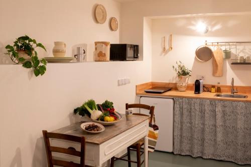 a kitchen with a table with a bowl of vegetables on it at Trulli Milena in Putignano