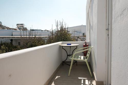 a small table and a chair on a balcony at Angela's Rooms in Mýkonos City