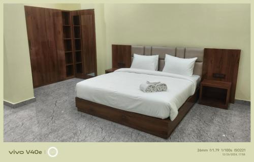 a bedroom with a large bed with white sheets at The Grand Inn Resort in Dum Duma