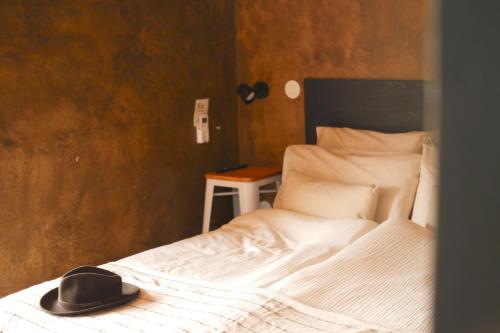 a hat sitting on a bed in a bedroom at Villa Várzea - Barn Nest in Várzea