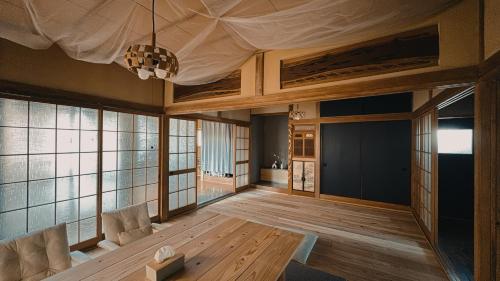 a living room with a table and some windows at Eastern sunrise home Valuable historical Japanese-style exclusive 4mins to ocean in Choshi