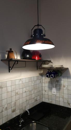 a light hanging over a sink in a kitchen at Casa Magdeburg I - Central e Aconchegante in Pomerode
