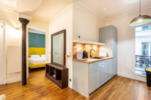 Il comprend une chambre et une cuisine avec un évier. dans l'établissement Stay in the Heart of Le Marais!, à Paris