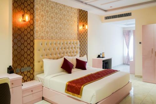 a bedroom with a large white bed in a room at Hotel Yathin in Mysore