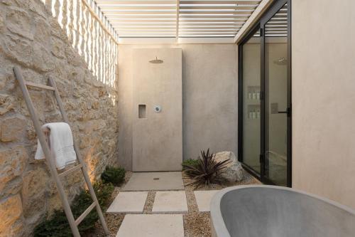 a bathroom with a stone wall and a bath tub at Ren House Luxury Nature Retreat in Yucca Valley