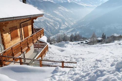 a building covered in snow next to a mountain at Thyon 4pièces, magnifique vue in Hérémence