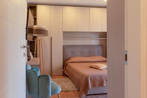 a bedroom with a bed and two blue chairs at Suite Strasburgo in Palermo