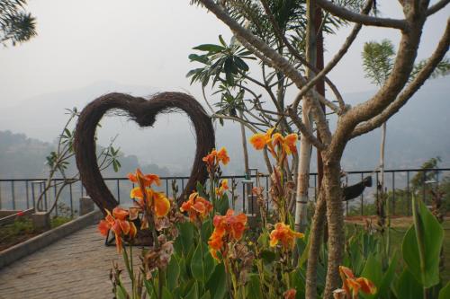 a heart sculpture in a garden with flowers at The Fern Heaven on The Hills Resort, Hatgad-Saputara in Surgāna
