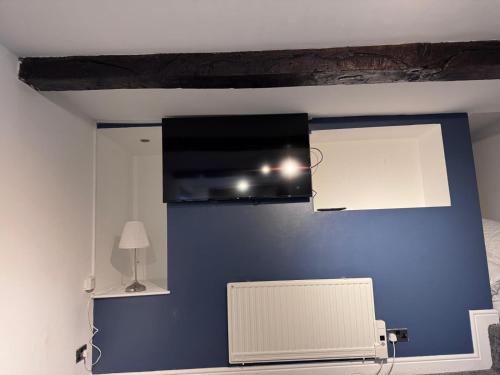 a room with a blue wall with a tv on it at Stafford apartments in Stafford