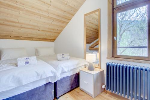 - 2 lits dans une chambre avec une fenêtre et un radiateur dans l'établissement Chanterelle apartement - Snow and Trek - Morzine, à Morzine
