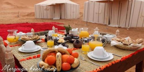 a table with food and orange juice on it at Merzouga heart camp in Merzouga