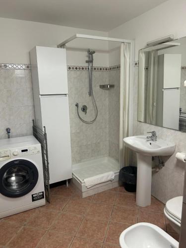 a bathroom with a shower and a sink and a washing machine at Residence La Lanterna in Genoa