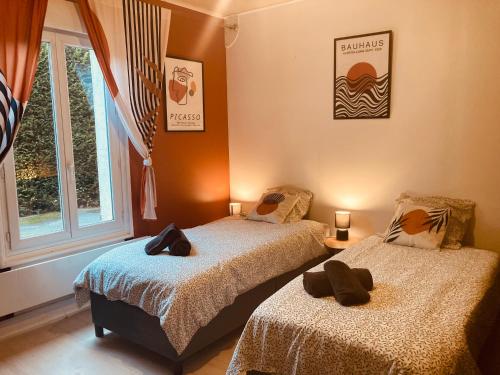 deux lits assis dans une pièce avec une fenêtre dans l'établissement T1 Confortable avec parking, proche Lyon, Idéal couples ou travailleurs, à Corbas